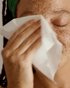 Person using a face wipe from The You Did It Bag