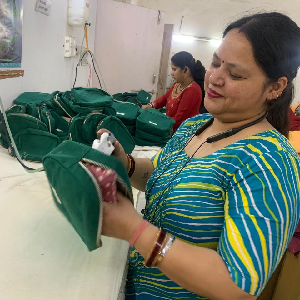 Woman sewing a green pouch for The You Did It Bag at Work+Shelter